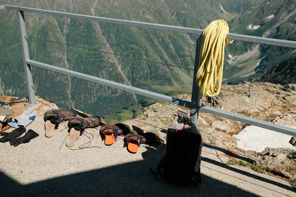 Climber wearing a safety peak shield helmet on rocky ridge at sunrise