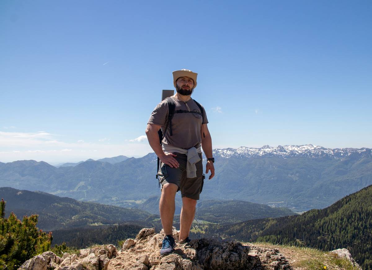 Climber wearing helmet summit protection while ascending a rocky cliff face