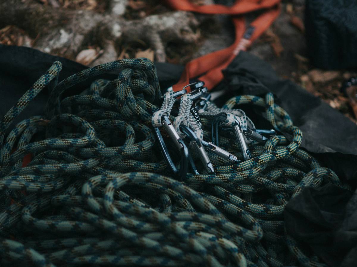 Climber wearing a summit climbing guard while ascending a rocky cliff face